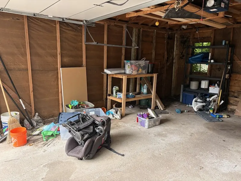 Detached garage before cleanout — cluttered with equipment and a workbench